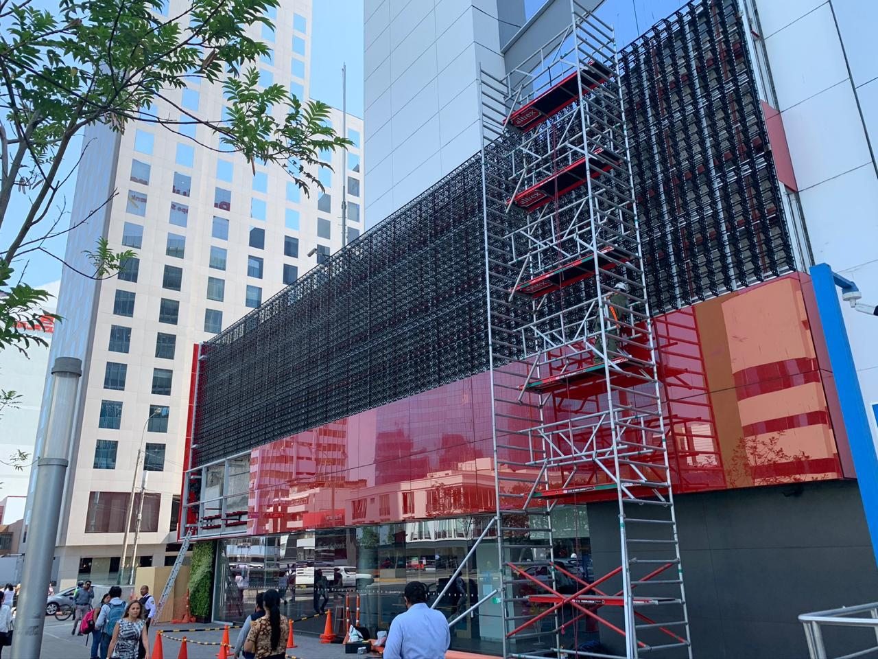 Equipe instalando jardim vertical em fachada comercial